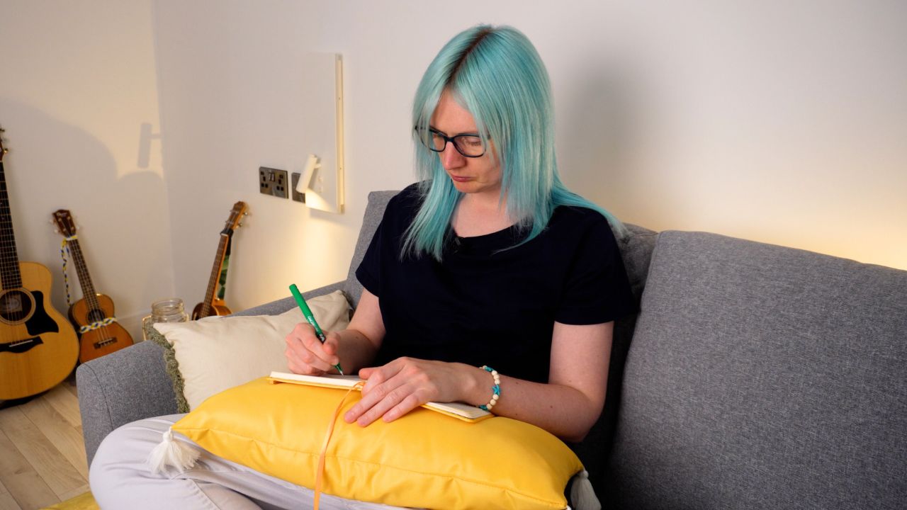 emily on sofa writing in notebook