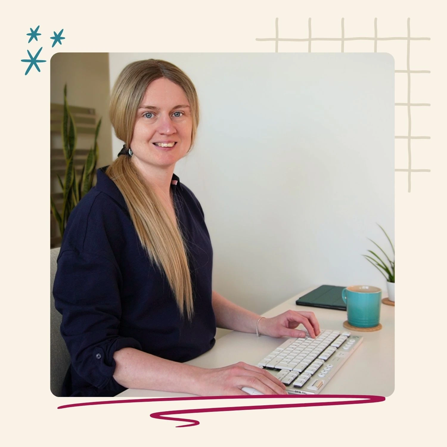 emily typing at her desk smiling to the camera
